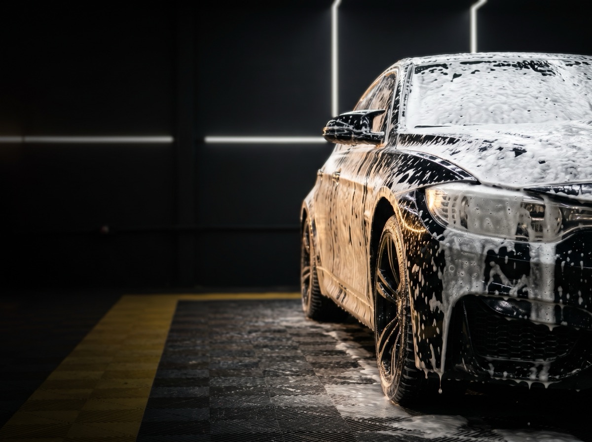 Carro escuro coberto de espuma na lavagem detalhada