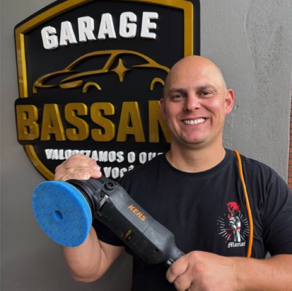Lucas Bassani segurando uma politriz em frente ao logo da Garage Bassani